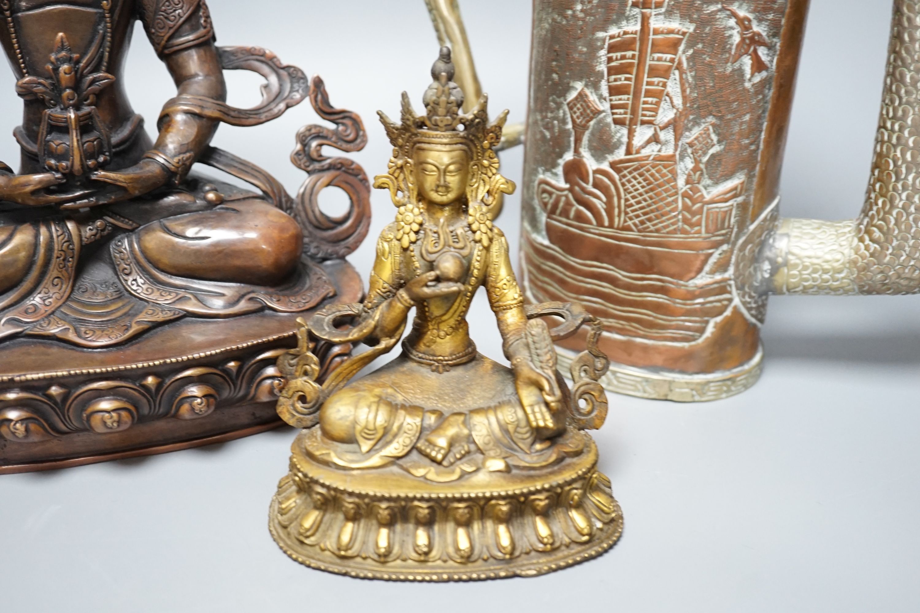 A Tibetan copper and brass ewer, together with a gilt-metal bodhisattva and another bronze bodhisattva, tallest 31cm